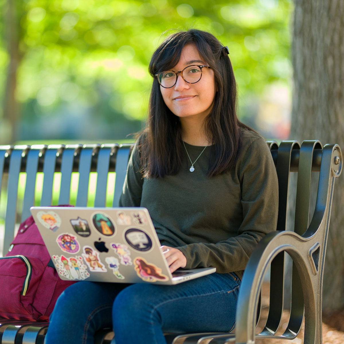 USU student on a bench using a laptop.