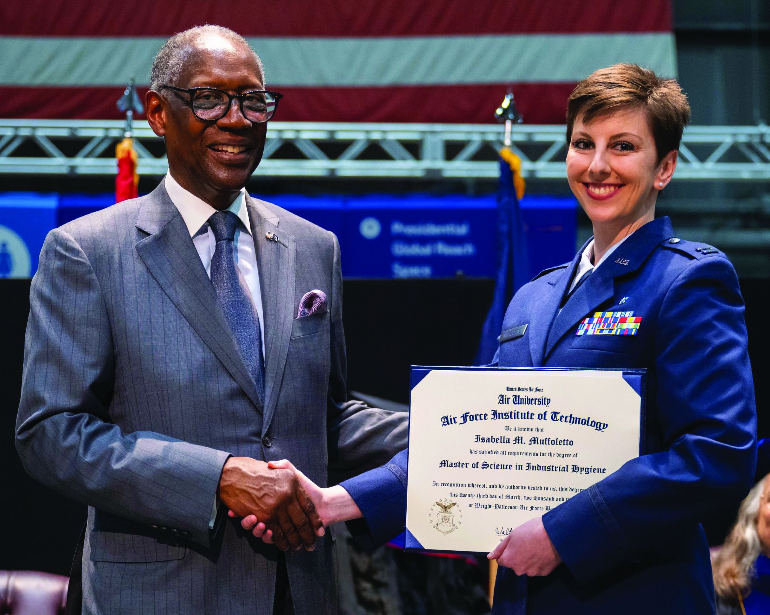 Capt. Isabella Muffoletto, right, receives her master’s degree diploma in industrial hygiene from General Lester Lyles 