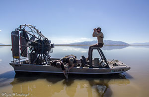 Side shot of man on a boat using binoculars