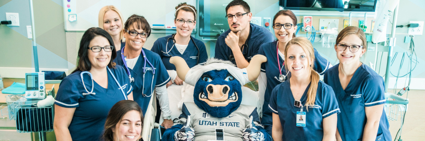Nursing students surrounding Big Blue in a medical bed