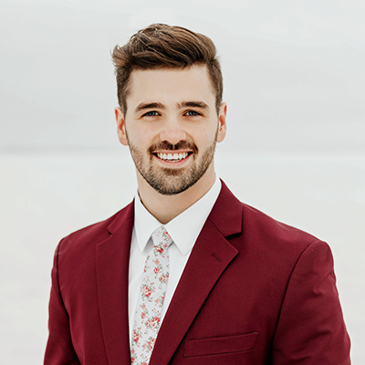 photo of man in a burgundy suit and tie