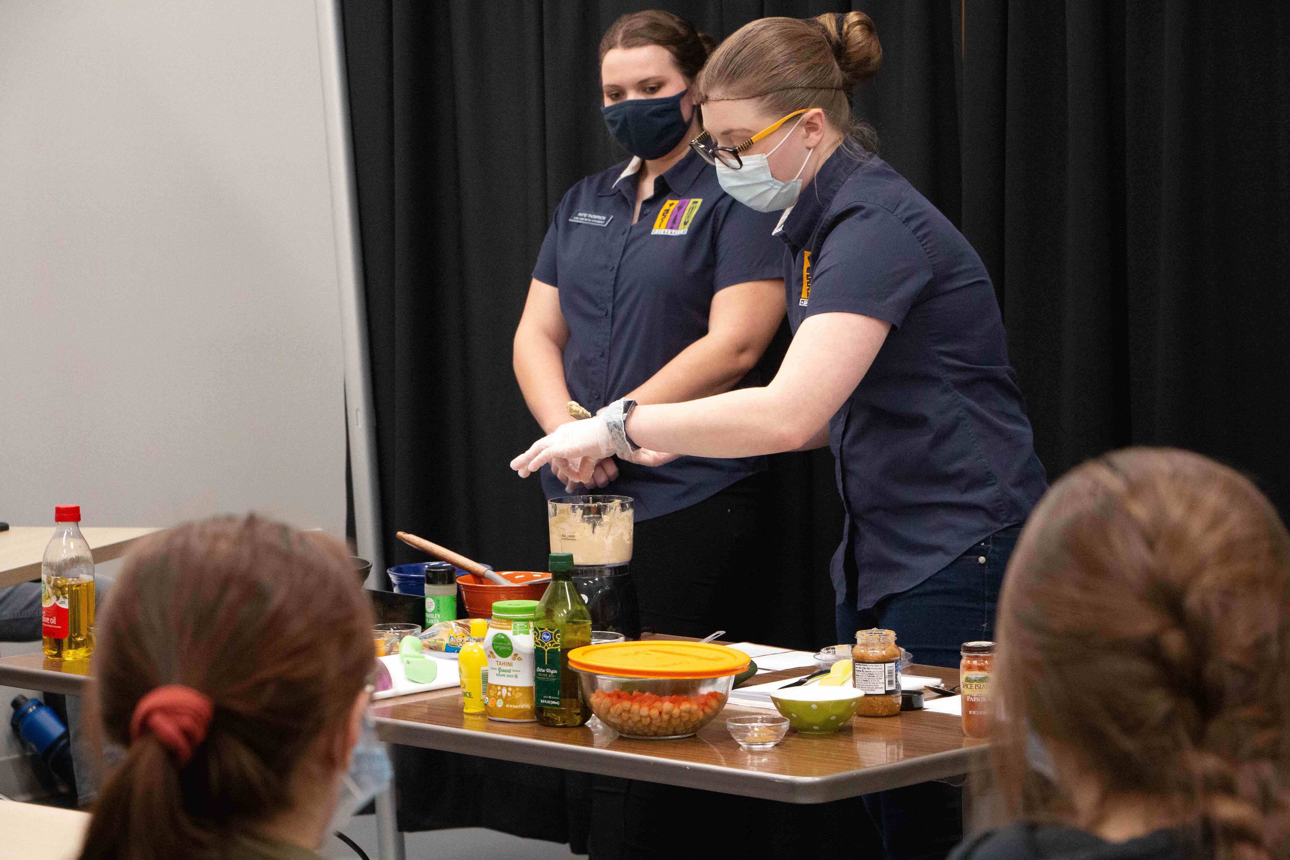Students teaching a nutriton class, showcasing how to cook.