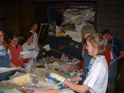 A group of volunteers sorts through paper recycling
