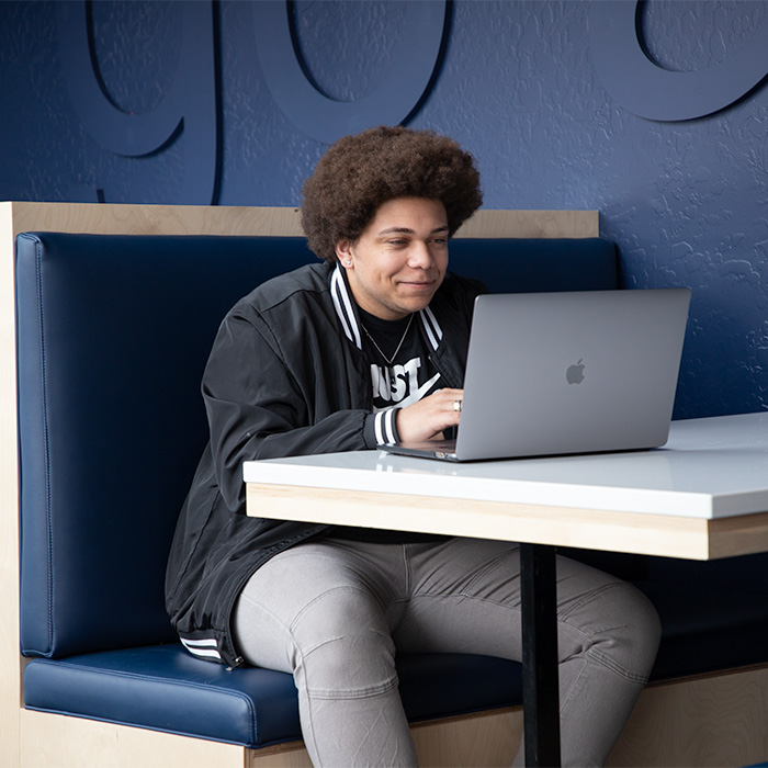 Student using laptop in Canyon Crest Suites study booth