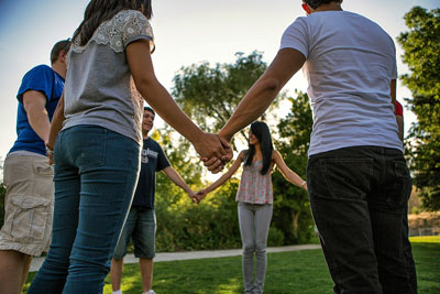 Group of youth holding hands, standing in a circle