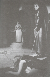 Production photograph of a modern performance of Aeschylus' Agamemnon, with Clytemnestra, Cassandra and Agamemnon together on stage (click to see larger image)