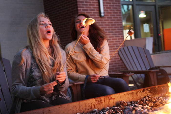students laughing at flaming marshmallows