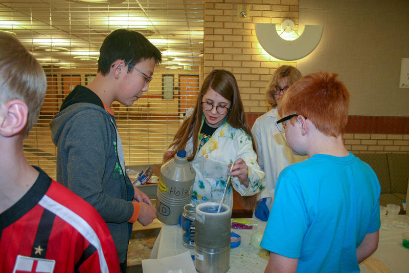 Students gather around an experiment