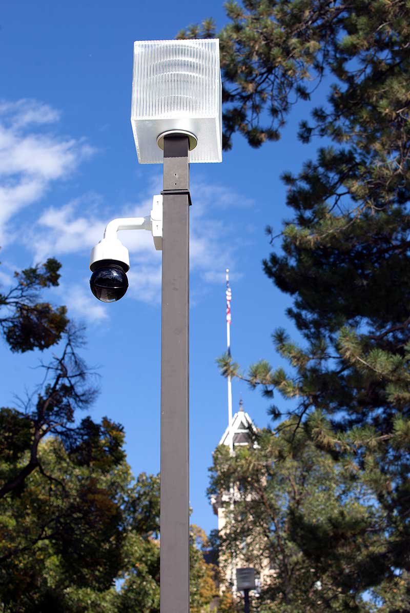 a security camera affixed to a street lamp on Old Main