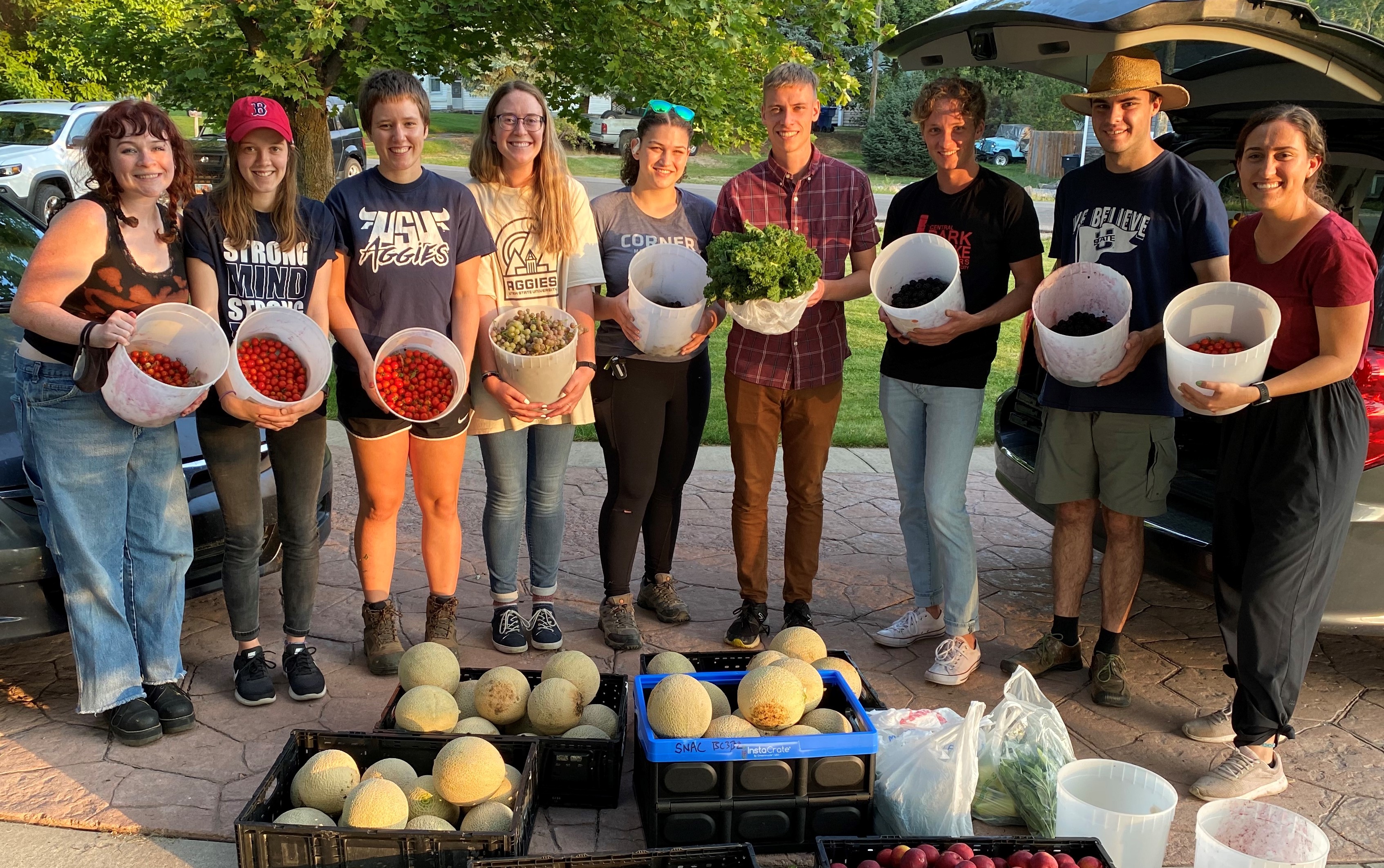 Group of people holding buckets of produce