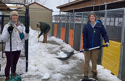 two volunteers with snow shovels