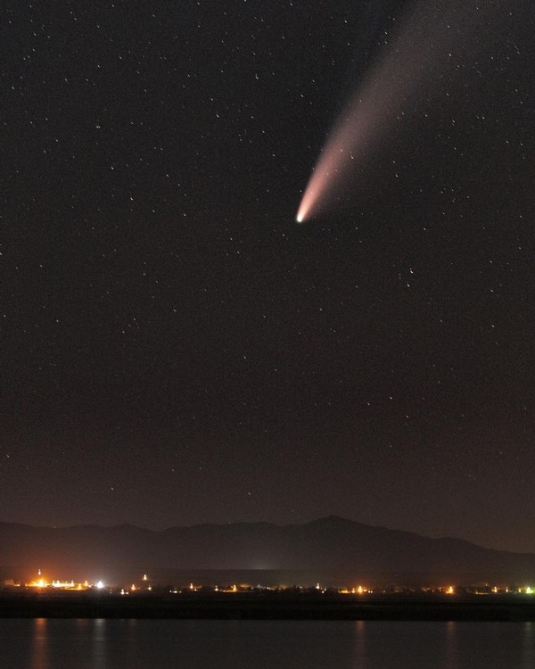 The NEOWISE comet streaks through the sky above the Benson Marina at night