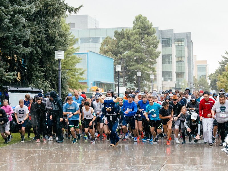 Racers start the homecoming 5k in the pouring rain.