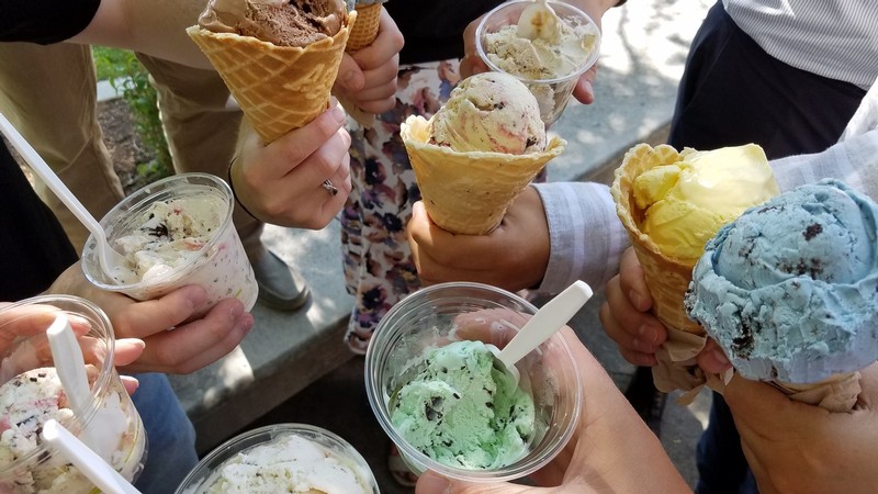 People holding Aggie Ice Cream cups and cones.