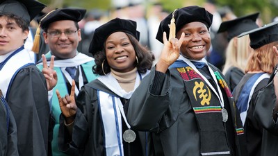 USU students in cap and gown show excitement about graduating