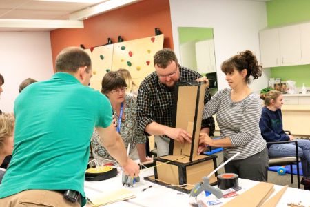 Clay demonstrates how to make a chair for children out of cardboard and other common materials.