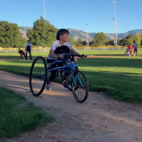 Kevin, young boy, using frame runner to run between bases during T Ball